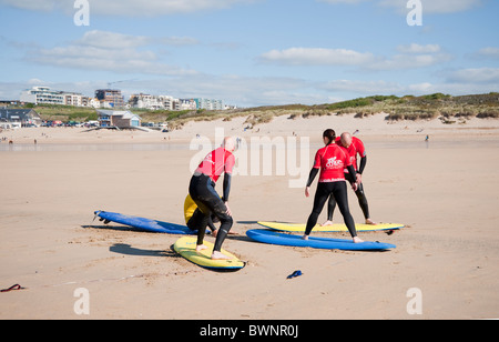 Lernen zu surfen in der Surfschule am Sandstrand von Fistral Beach, Newquay, Cornwall, UK Stockfoto