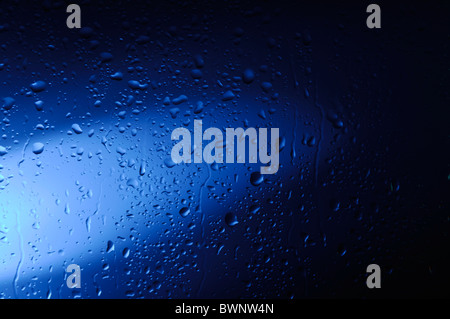 Feuchten Glas mit Wassertropfen im blauen Licht abstrakte künstlerische Hintergrundtextur Stockfoto