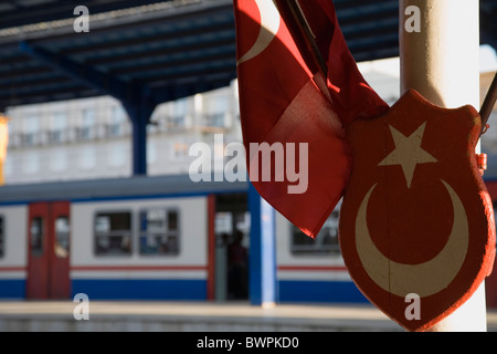 Türkei Istanbul Sultanahmet Sirkeci Gari Terminal Bahnhof, türkische Flagge und Wappen im Vordergrund mit dem Zug am Bahnsteig Stockfoto