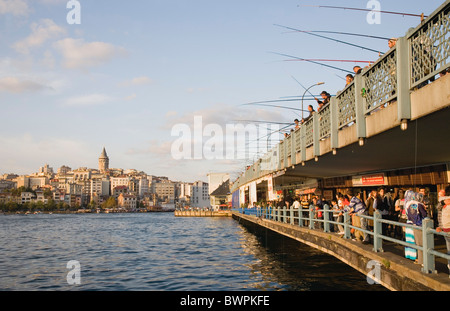 Türkei Istanbul Sultanahmet Blick Richtung Galata-Turm mit Männer Angeln vom Galata-Brücke am Goldenen Horn über Fisch-Restaurants. Stockfoto