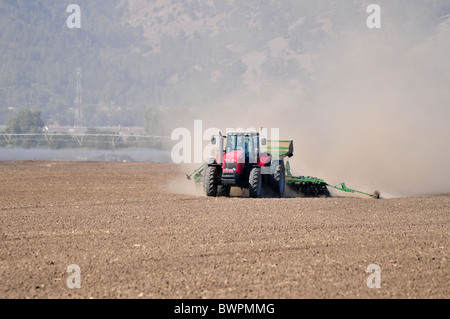 Israel, Hula-Tal, Traktor Pflüge und Kassen ein Feld Stockfoto