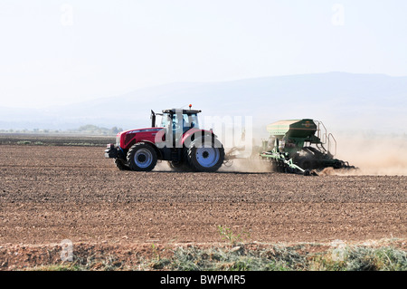 Israel, Hula-Tal, Traktor Pflüge und Kassen ein Feld Stockfoto