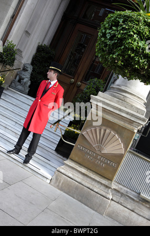 Elegant in seinem roten Uniform gekleidet, die Pförtner des Mandarin Oriental Hyde Park Hotel in Knightsbridge, London. Stockfoto