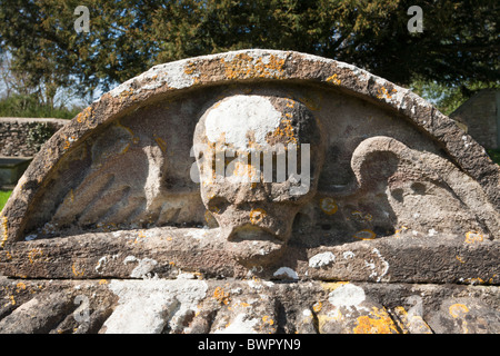 Ein geflügelter Totenkopf auf einem Grabstein auf dem Friedhof von Cotswold in Fairford, Gloucestershire Stockfoto