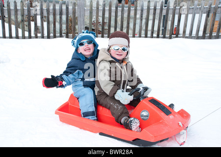 Zwei jungen entlang auf einem Schlitten gezogen wird. Stockfoto