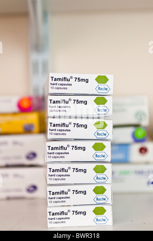 Stapel von Kisten mit Tamiflu antivirale Tabletten auf einem Regal in einer Apotheke Stockfoto