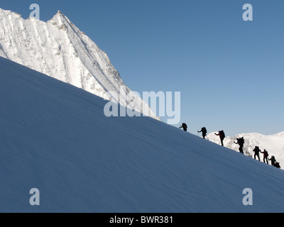 Skitourengeher aufsteigender Glacier de Tsena Refien, unten Mont Blanc de Cheilon auf der Haute Route, Schweiz. Stockfoto