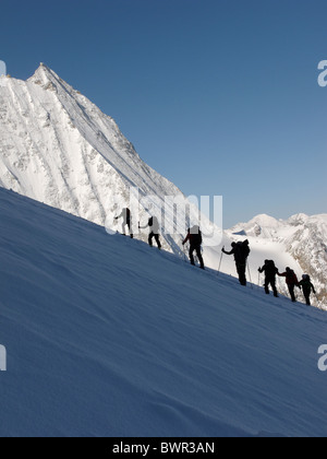 Skitourengeher aufsteigender Glacier de Tsena Refien, unten Mont Blanc de Cheilon auf der Haute Route, Schweiz. Stockfoto