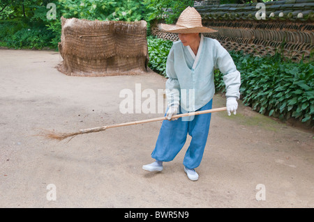 Man fegt einen Feldweg tragen traditionelle Kleidung, Korea Folk Village, Suwon, Südkorea Stockfoto