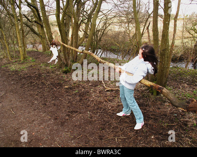 Junge Mädchen spielen mit Jack Russell Terrier Hund und große Filiale Stockfoto