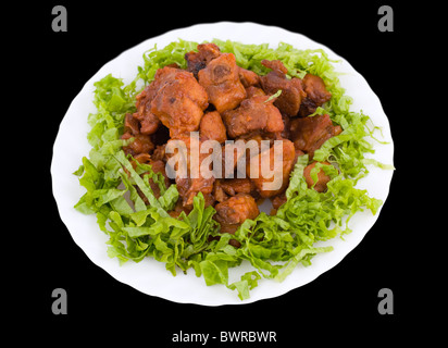 Chinesisches Essen. Gebratene Schweinerippchen mit Blattsalat, isoliert auf schwarz. Stockfoto