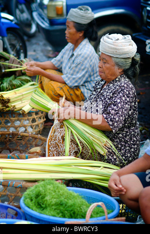 In den frühen Morgenstunden verkaufen die Markt-Damen in Bali, Indonesien, ihre frische Lebensmittel, Süßwaren, Fisch und Blumen. Stockfoto