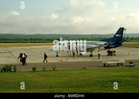 Passagiere steigen Sie aus einer Propellermaschine bei Santa Elena Flughafen oder Mundo Maya Flughafen, El Petén, Guatemala Stockfoto