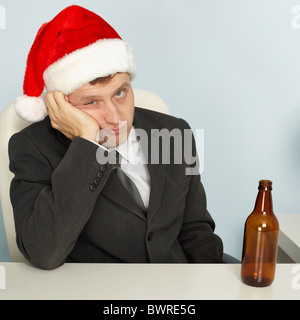 Ein trauriger junger Mann leiden einen Kater nach Weihnachten Stockfoto