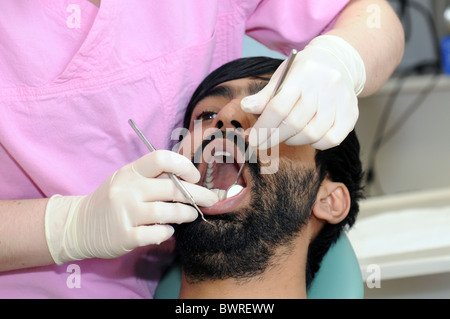 Ein asiatischer Mann, nachdem eine zahnärztliche Untersuchung durch eine Zahnärztin Stockfoto