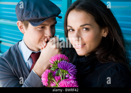 Foto von verliebten Mann küsst seine Freundin Hand, während sie den Blick in die Kamera Stockfoto