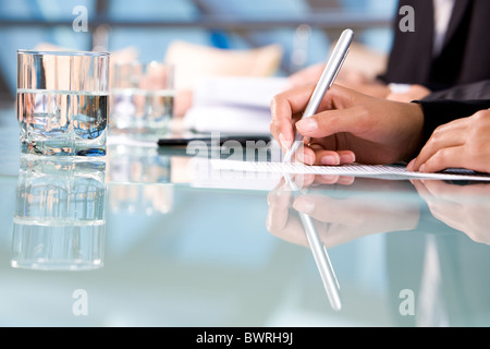 Menschliche Hände halten Sie Stift und Notizen während der Konferenz Stockfoto
