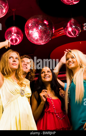 Hübsche Mädchen in Disco mit glücklicher Kerl hinter verschieben Stockfoto