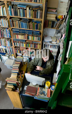 Second-Hand Buchladen-Besitzer bei der Arbeit in Falmouth, Cornwall Stockfoto