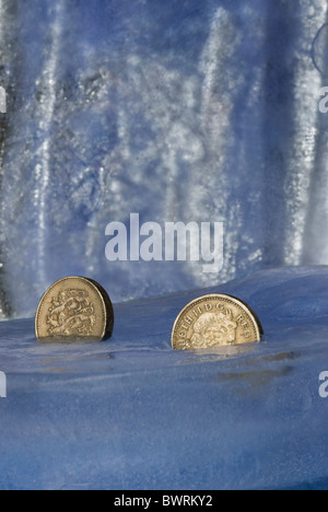 Gefrorene Pfund - Münzen in Eis Wirtschaft ausgesetzt Stockfoto
