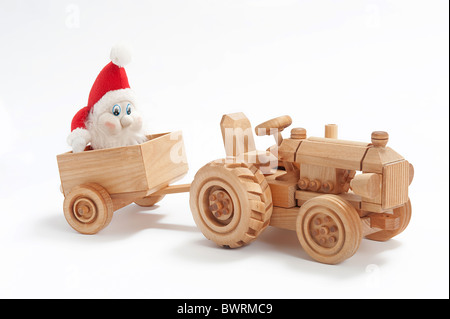 Weihnachtsgeschenk mit Spielzeug-Traktor und Gnome in Anhänger Stockfoto