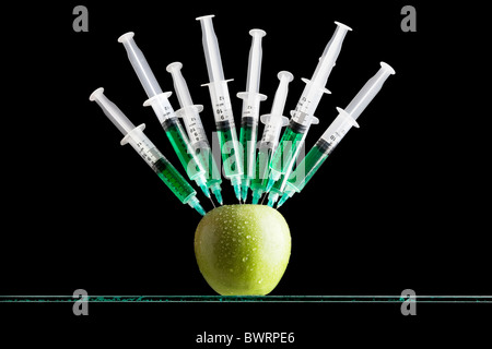 Spritzen in einen Apfel stecken Stockfoto