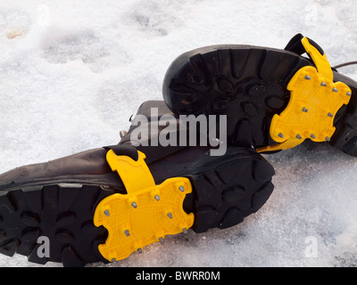 Sohlen von ein paar Herren Wanderstiefel mit Steigeisen ausgerüstet für Sicherheit auf Schnee und Glatteis Stockfoto