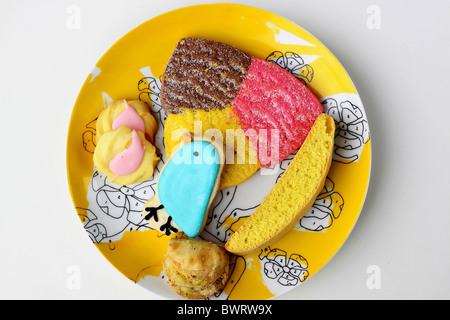 Eine gelbe retro Platte gestapelt mit sechs bunte Cookies. Stockfoto