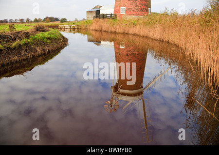 Die Windpumpe der Windmühle Horsey spiegelte sich in einem mit Schilf gesäumten Deich in Norfolk Broads wider. Horsey Norfolk England Großbritannien Stockfoto
