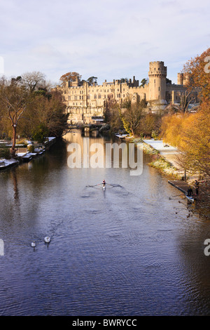 Warwick Castle & Fluss Avon mit einem leichten Abstauben von Schnee.  2 Schwäne & ein Ruderer auf dem Fluss mit einem anderen Ruderer bereit, auf den Weg. Stockfoto