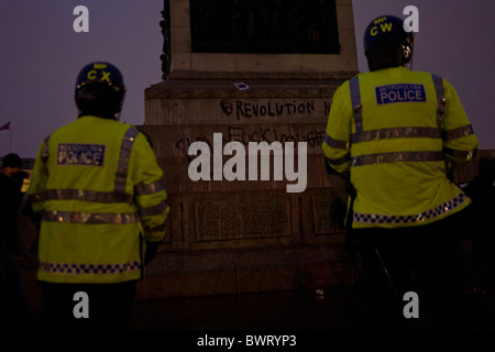 Studentenproteste in Trafalgar Square Riot Polizisten mit revolutionären Graffiti auf die Nelsonsäule tagte. Stockfoto