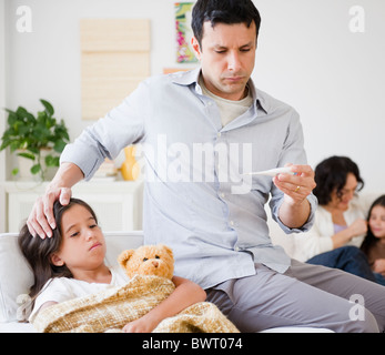 Vater nehmen kranke Tochter Temperatur mit thermometer Stockfoto