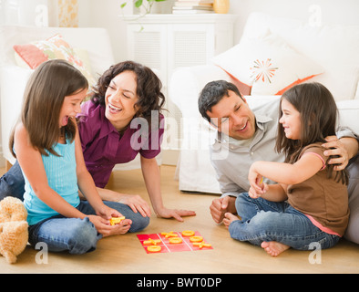 Vater und Mutter spielen im Wohnzimmer mit Kindern Stockfoto