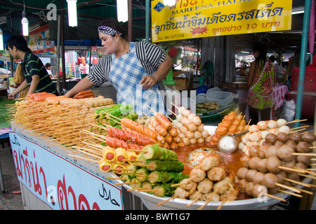Frau Verkäufer Verkauf aufgespießt Essen auf Wochenendmarkt Phuket, Thailand Stockfoto