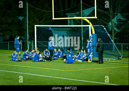 High School soccer Coach gibt Halbzeit pep sprechen Sie mit Team. Stockfoto