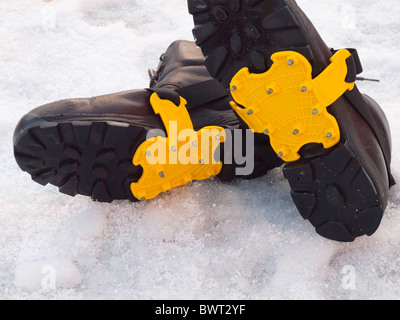 Sohlen von ein paar Herren Wanderstiefel mit Steigeisen ausgerüstet für Sicherheit auf Schnee und Glatteis Stockfoto