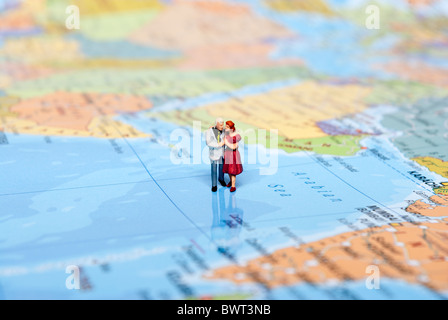 Miniatur-Mann auf Weltkarte Stockfoto