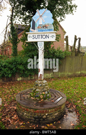 Sutton, Norfolk, England, Vereinigtes Königreich, Europa. Reich verzierte Dorf Schild mit Windmühle und lokale Besonderheiten der Broads Stockfoto