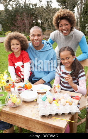 Familie Malerei Ostereier im Garten Stockfoto