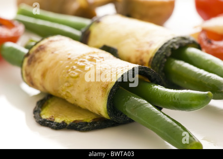 Bohnen in Auberginenscheiben als Closeup auf einem weißen Teller gerollt Stockfoto