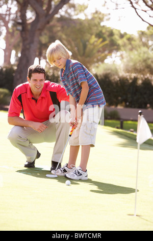 Vater Lehre Sohn Golf spielen, auf grün Stockfoto