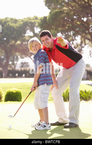 Vater Lehre Sohn Golf spielen, auf grün Stockfoto