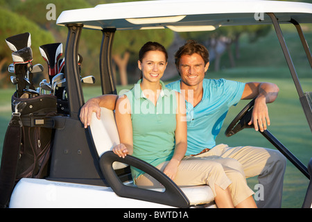 Paar In Golfbuggy fahren auf Golfplatz Stockfoto