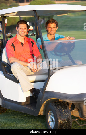Zwei männliche Golfer Reiten Golfbuggy auf Golfplatz Stockfoto