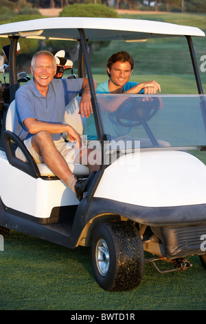 Zwei männliche Golfer Reiten Golfbuggy auf Golfplatz Stockfoto