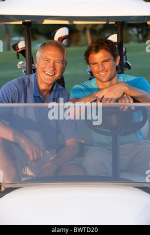 Zwei männliche Golfer Reiten Golfbuggy auf Golfplatz Stockfoto