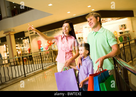 Porträt von hübschen weiblichen zeigen etwas zu ihrem Mann und ihrem Sohn während des Einkaufs Stockfoto