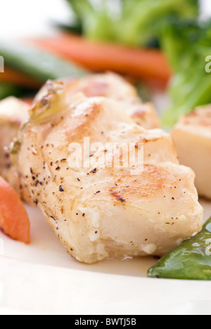 Red Snapper Filets mit Gemüse als Closeup auf einem weißen Teller Stockfoto