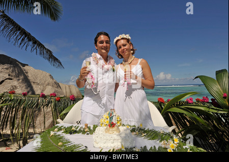 Brautpaar mit Gläsern Champagner in La Digue, Seychellen Stockfoto