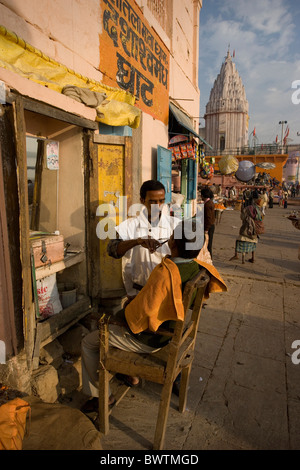 Uttar Pradesh Varanasi in Indien Stadt Benares Street Szene Asien reisen Januar 2008 Barbier Friseur Mann Pers. Stockfoto